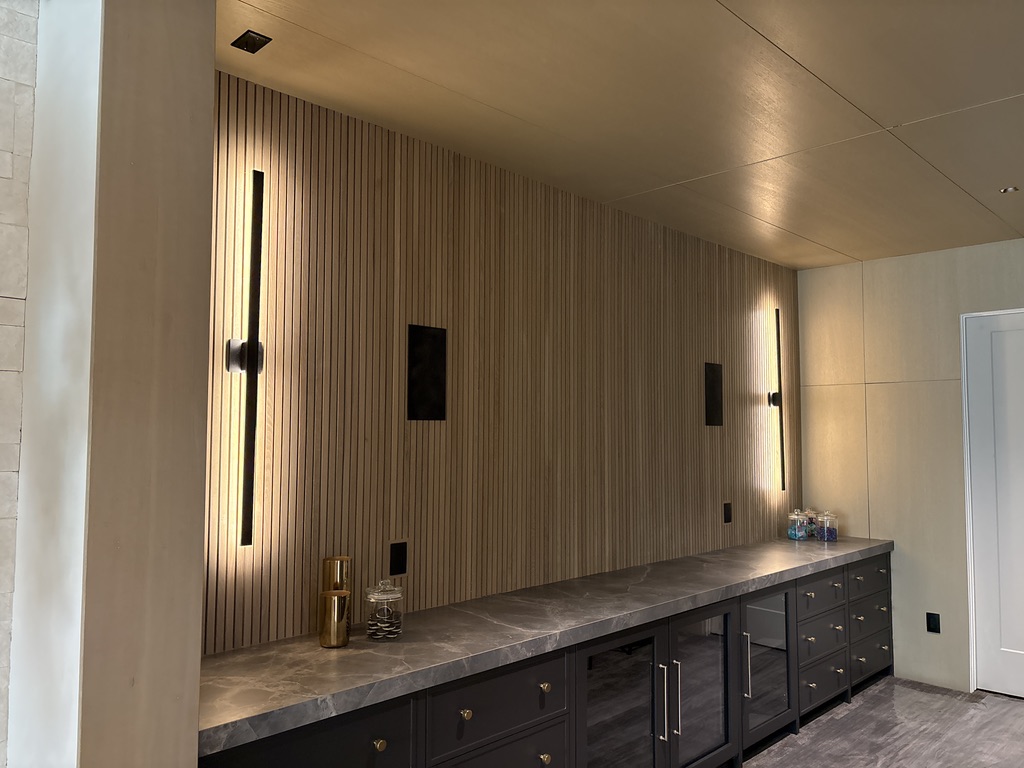 Custom wood slat entertainment wall with built-in cabinetry and integrated lighting