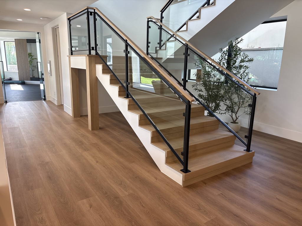 Custom oak stair treads with glass panel and steel rail system, luxury custom home